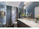 Bathroom featuring a dark wood vanity, marble countertop, and a shower with patterned curtains at 3188 Verbena Ct, Deltona, FL 32725