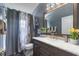 Bathroom featuring a dark wood vanity, marble countertop, and a shower with patterned curtains at 3188 Verbena Ct, Deltona, FL 32725
