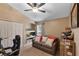 Bedroom featuring a sleeper sofa, built-in shelving, ceiling fan, and a study space at 3188 Verbena Ct, Deltona, FL 32725