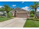Charming single-Gathering home with a well-manicured lawn, mature palm trees, and a two-car garage at 3188 Verbena Ct, Deltona, FL 32725