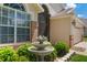 Close up of charming front yard, featuring a fountain, lush landscaping, and brick accents for a welcoming appeal at 3188 Verbena Ct, Deltona, FL 32725