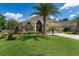 Beautifully landscaped front yard featuring lush green grass, palm trees, and a charming fountain near the front entrance at 3188 Verbena Ct, Deltona, FL 32725