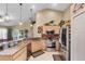 Well-appointed kitchen with stainless steel appliances, wood cabinets, and a view into the game room at 3188 Verbena Ct, Deltona, FL 32725
