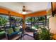 Inviting sunroom featuring comfortable seating, a ceiling fan, and views of the landscaped backyard at 3188 Verbena Ct, Deltona, FL 32725