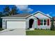 Charming single-story home with a two-car garage, gray stucco siding, red shutters, and a well-manicured lawn at 3418 Wynwood Forest Dr, Ocoee, FL 34761