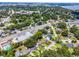 This aerial showcases houses on a tree-lined street, as well as lake and golf course views at 3474 Fairway Ln, Orlando, FL 32804