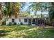 A bright, grassy backyard features a screened-in patio, bordered by mature trees and landscaping at 3474 Fairway Ln, Orlando, FL 32804