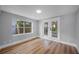 Bright bedroom with new flooring and trim, featuring a window and French doors to the backyard at 3474 Fairway Ln, Orlando, FL 32804