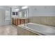 Bright bathroom boasts a soaking tub, tile surround, double vanity, and natural light at 3530 Rodrick Cir, Orlando, FL 32824