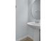 A pedestal sink and round mirror against a neutral backdrop in the bathroom at 3530 Rodrick Cir, Orlando, FL 32824