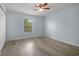 This light blue bedroom features a ceiling fan, wood floors and natural light from the window at 3530 Rodrick Cir, Orlando, FL 32824