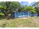 Spacious backyard showing the home's blue siding, AC unit, and a small storage shed, all under a sunny sky at 4515 Isaac Ln, Sanford, FL 32771