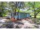 Charming single-story home with a covered porch, blue siding, and mature shade trees in the front yard at 4515 Isaac Ln, Sanford, FL 32771