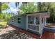 Home with blue siding, a covered porch, and a white railing, complemented by carefully placed mulch landscaping at 4515 Isaac Ln, Sanford, FL 32771