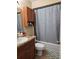 Well-lit bathroom with a shower-tub combo and tiled floors and dark vanity at 4936 Tangerine Ave # 4936, Winter Park, FL 32792