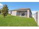 Backyard featuring a covered patio with outdoor seating, a well-manicured lawn, and a partial privacy fence at 567 Pinecrest Loop, Davenport, FL 33837