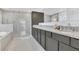 Bright bathroom featuring a glass enclosed shower, soaking tub, and double sink vanity with granite countertops at 567 Pinecrest Loop, Davenport, FL 33837