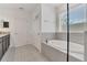 Bathroom featuring a modern soaking tub with chrome fixtures, a large window, and tile flooring at 567 Pinecrest Loop, Davenport, FL 33837