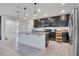 Modern kitchen featuring dark cabinetry, stainless steel appliances, and pendant lighting at 567 Pinecrest Loop, Davenport, FL 33837