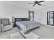 Main bedroom featuring a ceiling fan, a chair and bedside table, and a crib, providing a cozy escape at 567 Pinecrest Loop, Davenport, FL 33837