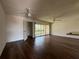Well-lit living room features hardwood floors, a ceiling fan, and sliding doors leading to the balcony at 592 Orange Dr # 142, Altamonte Springs, FL 32701