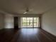 Open-concept living room with a ceiling fan and sliding glass doors to the outdoor balcony at 592 Orange Dr # 142, Altamonte Springs, FL 32701