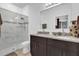 En-suite bathroom featuring double sinks, granite countertops, and a frameless glass shower at 606 Marion Oaks Blvd, Ocala, FL 34473