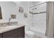 Bathroom features a granite vanity, modern fixtures, and a shower-tub combo with tiled walls at 606 Marion Oaks Blvd, Ocala, FL 34473
