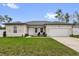 Charming single-story home with a well-manicured lawn, two rocking chairs, and an attached two-car garage at 606 Marion Oaks Blvd, Ocala, FL 34473