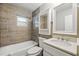 Bathroom featuring bathtub, shower, modern vanity, with stone tile and bright lighting at 606 Ohio Ave, St Cloud, FL 34769