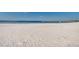 Sandy beach with a volleyball net, offering a relaxing day by the clear blue water at 606 Ohio Ave, St Cloud, FL 34769