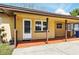 Close-up of a cozy home's covered porch, showcasing the entrance and side carport at 606 Ohio Ave, St Cloud, FL 34769