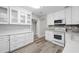 Well-lit kitchen with modern appliances, white cabinets, granite countertops, and durable luxury vinyl flooring at 606 Ohio Ave, St Cloud, FL 34769