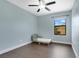 Bedroom featuring a window, ceiling fan, a grey toddler bed and hard wood floors at 617 Joyful Blossom Pl, Longwood, FL 32750
