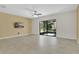 Living room featuring tile floors, a ceiling fan, a TV, and sliding glass doors to screened lanai at 617 Joyful Blossom Pl, Longwood, FL 32750