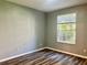 Comfortable bedroom with wood-look flooring and a bright window at 6451 Old Park Ln # 102, Orlando, FL 32835