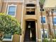 Attractive condo building with stairwell, large windows, and nearby mature trees and landscaping at 6451 Old Park Ln # 102, Orlando, FL 32835