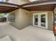 Covered patio with double glass doors and neutral stucco exterior at 721 Rock Creek Loop, Longwood, FL 32750