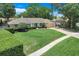 Aerial view of a well-maintained single-story home with lush landscaping and a brick paver driveway at 7549 Lake Marsha Dr, Orlando, FL 32819