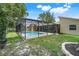 Well-maintained backyard with healthy green grass, a shade tree, and a screened-in pool area at 7549 Lake Marsha Dr, Orlando, FL 32819