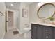 Modern bathroom with a glass shower, wooden framed circular mirror, and stylish vanity at 7549 Lake Marsha Dr, Orlando, FL 32819