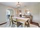 Bright dining room with wood table, seating for six, modern light fixture, and view of living room at 7549 Lake Marsha Dr, Orlando, FL 32819