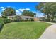Charming single-story home featuring a large lawn, manicured landscaping and a paver driveway at 7549 Lake Marsha Dr, Orlando, FL 32819