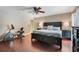 Main bedroom featuring an exercise bike, dark wood floors, and a large bed and nightstands at 7549 Lake Marsha Dr, Orlando, FL 32819