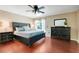 Well-lit main bedroom boasting a ceiling fan, dark wood floors, and a large bed and dresser at 7549 Lake Marsha Dr, Orlando, FL 32819