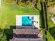 Aerial shot of a backyard featuring a pool, spa, and lush green landscaping at 7739 Graben St, Kissimmee, FL 34747