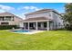 Beautiful backyard showcasing a sparkling pool and covered patio with ample seating at 7739 Graben St, Kissimmee, FL 34747