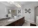 Bathroom featuring a granite countertop, double vanity, large mirror, and a glass-enclosed shower at 7739 Graben St, Kissimmee, FL 34747