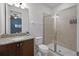 Bathroom featuring a single granite vanity, walk-in shower, and modern fixtures, offering both style and functionality at 7739 Graben St, Kissimmee, FL 34747
