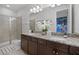 Bathroom with granite countertop, dual sinks, and a glass enclosed shower, with a peak at a Mario-themed bedroom at 7739 Graben St, Kissimmee, FL 34747